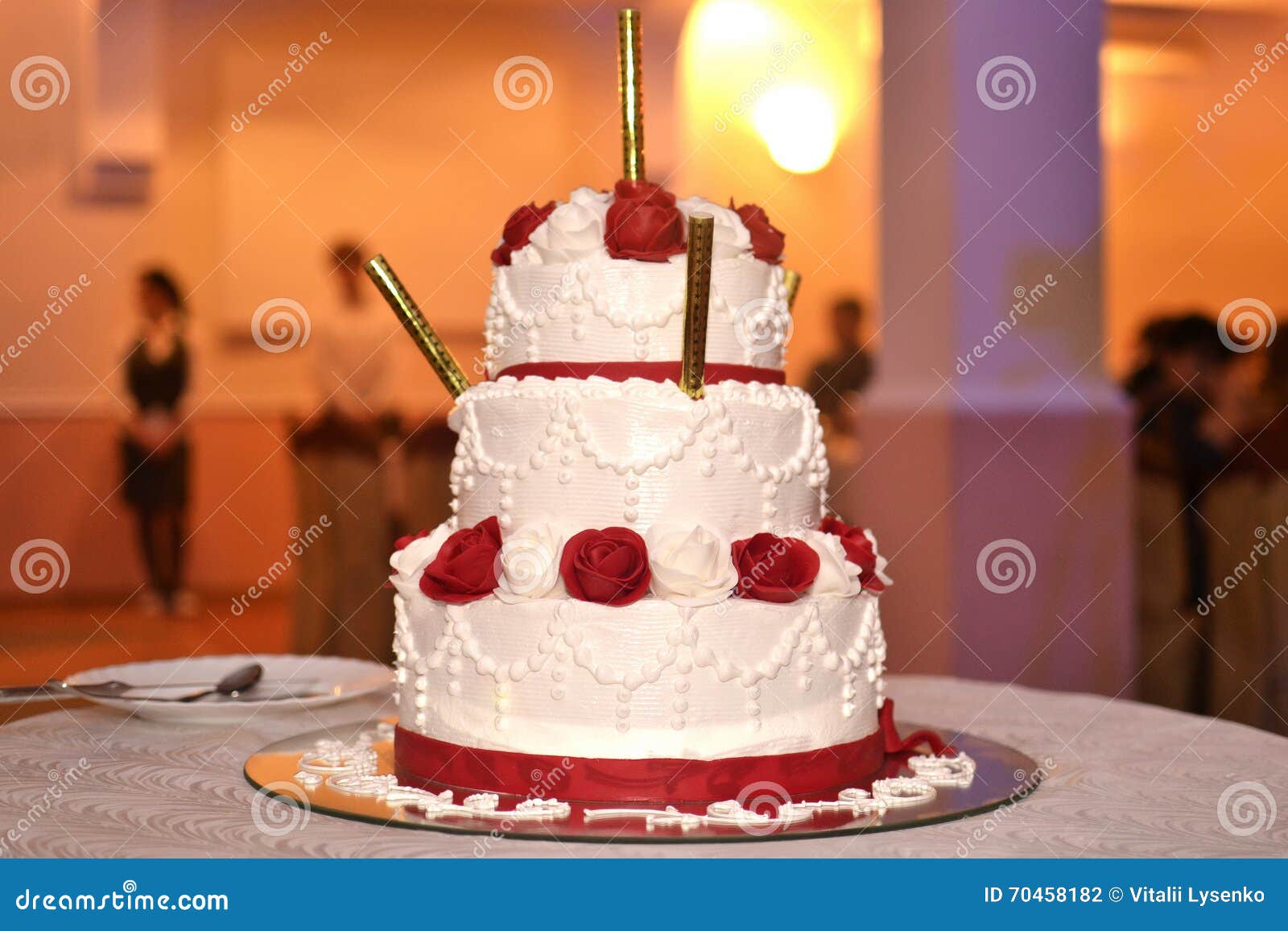Wedding Cake with Candles Decorated with Red Flowers Stock Photo