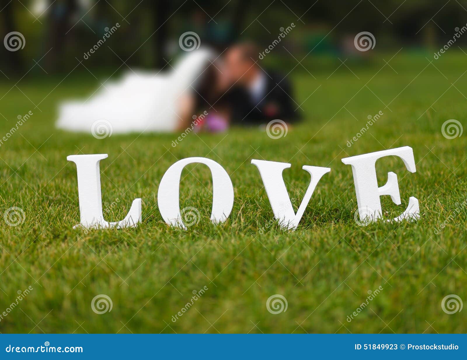 wedding couple unfocused and love word on the grass