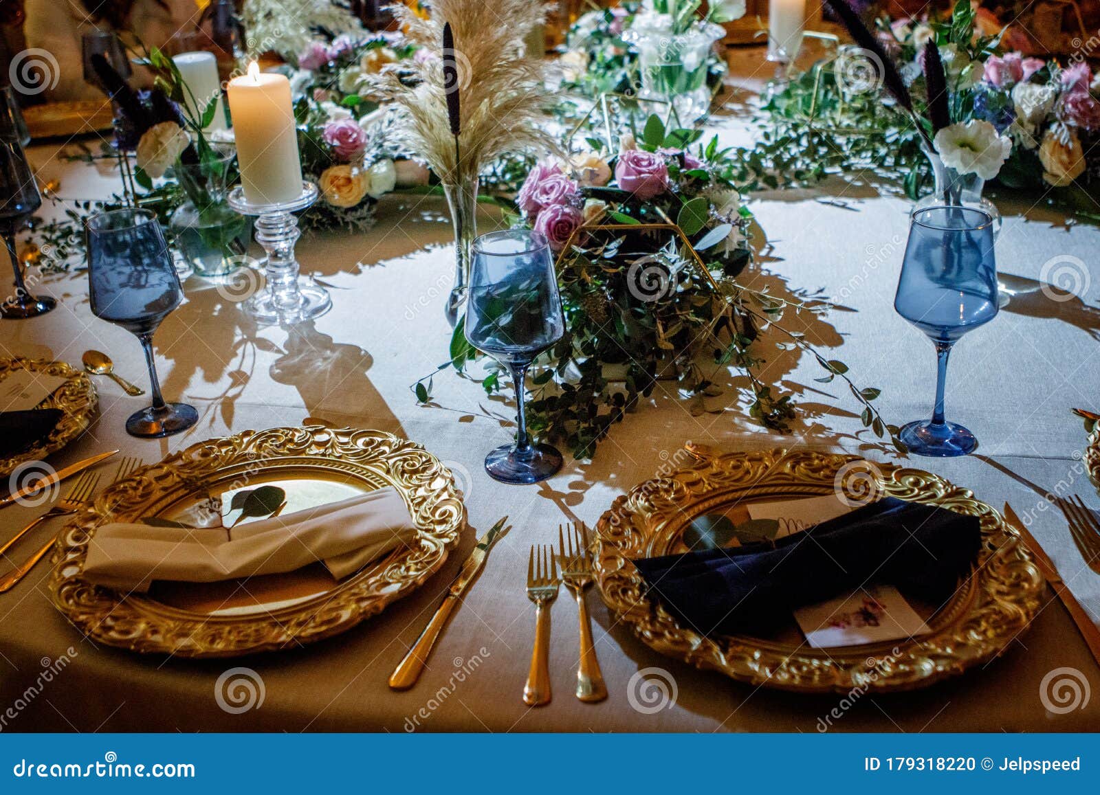 luxury table flower green decoration with blue glass globets wedding event party at night, coctel table with candles