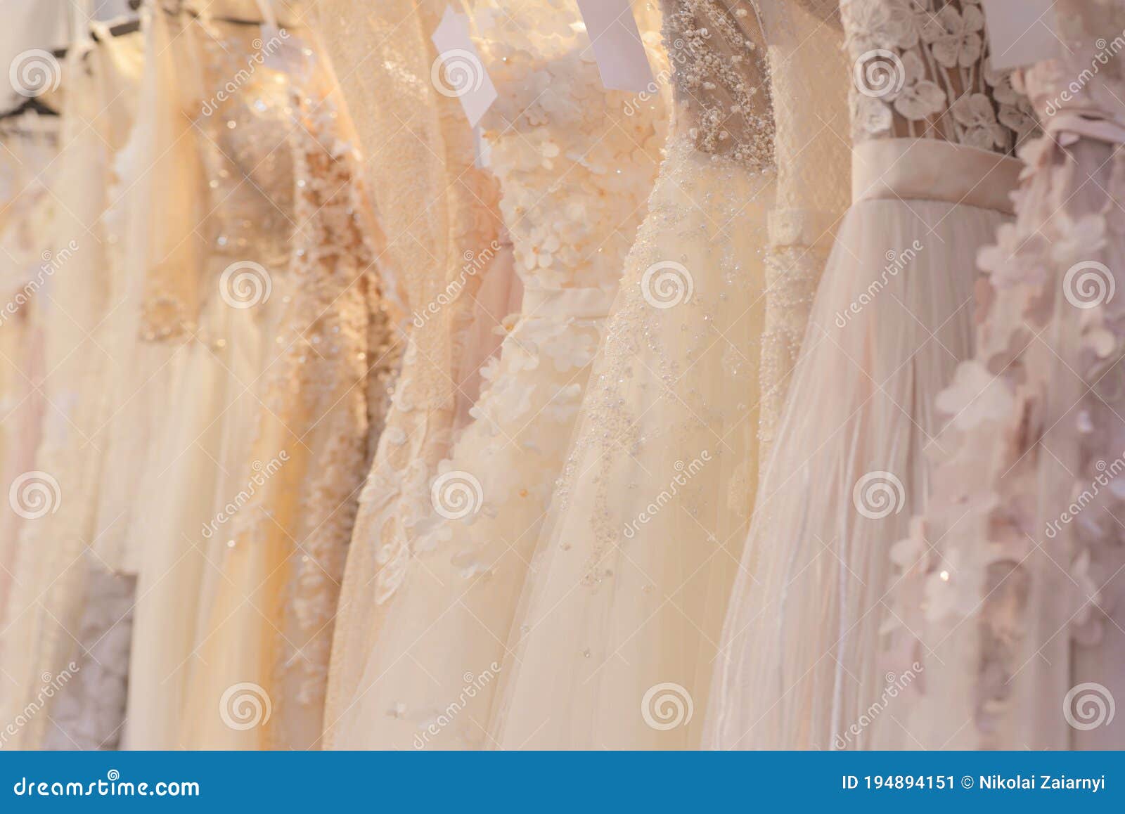wedding dresses hang on a hanger in a row