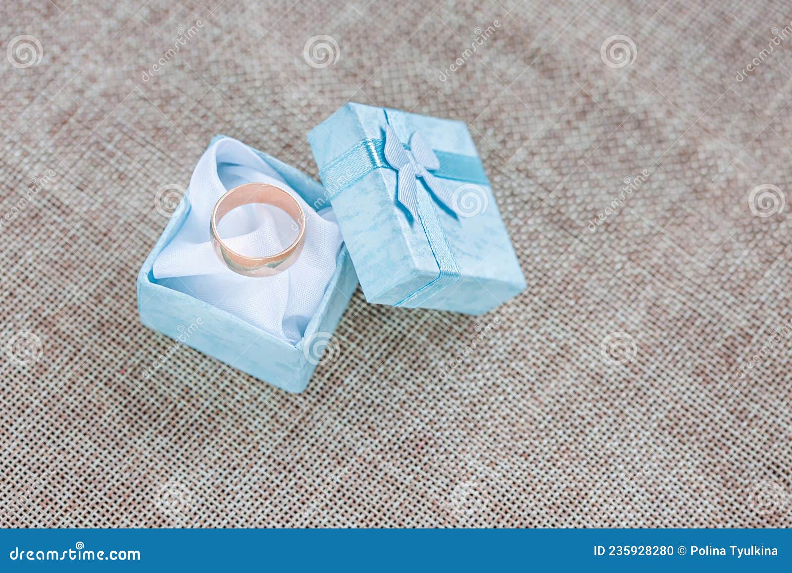 Wedding Ring on Blue Jewelry Box on Linen Background Stock Photo