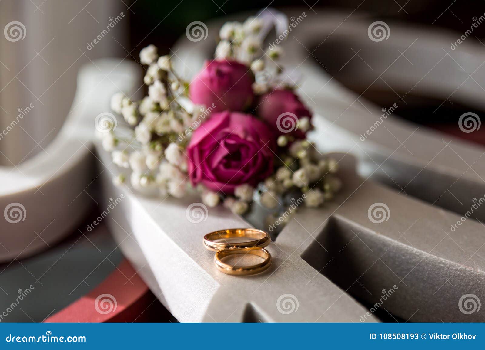 Wedding Rings are Lying on White Paper Carved into a Pattern Stock