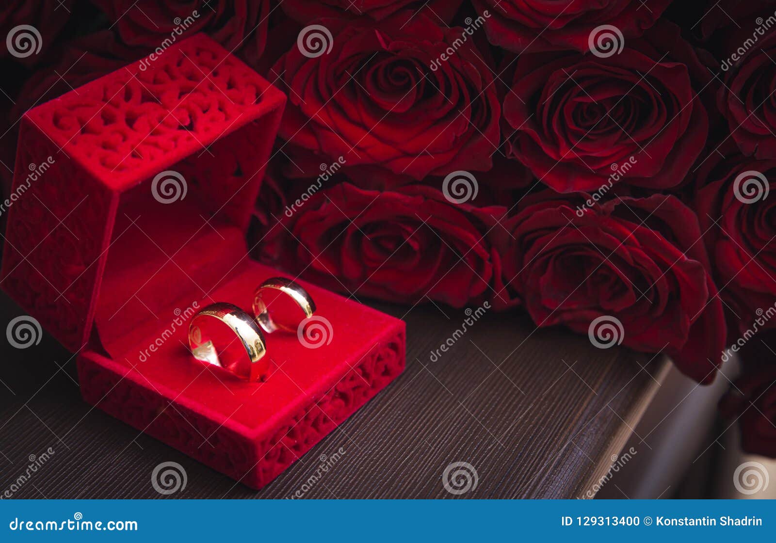 Wedding rings on red roses stock photo. Image of flower 129313400