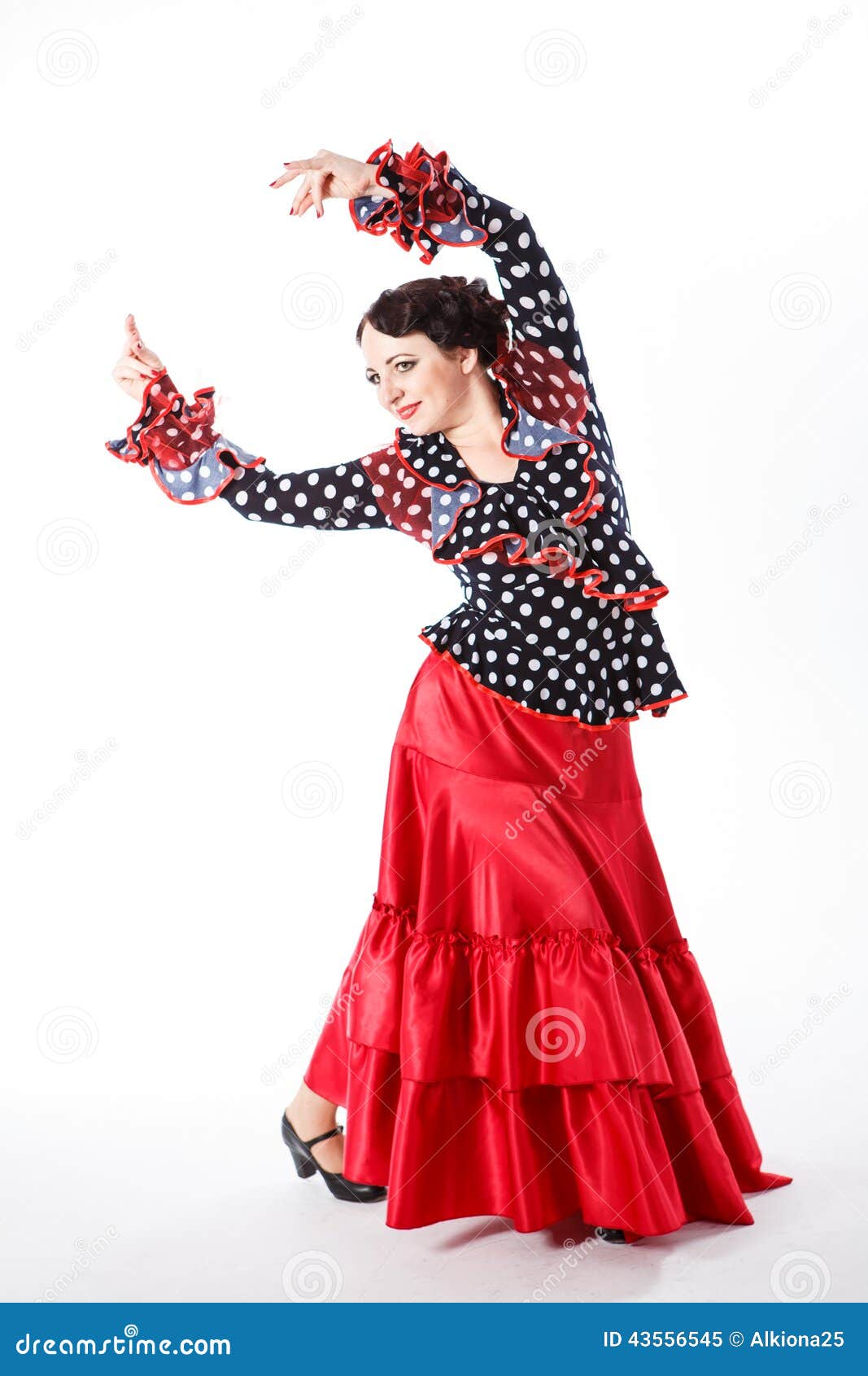 Weiblicher, spanischer Flamencotänzer. Umsäumen weiblicher spanischer Flamencotänzer des jungen schönen Brunette im schwarzen Hemd und roter Flamenco die Aufstellung mit rotem Fan in ihren Armen im Studio auf grauem Hintergrund