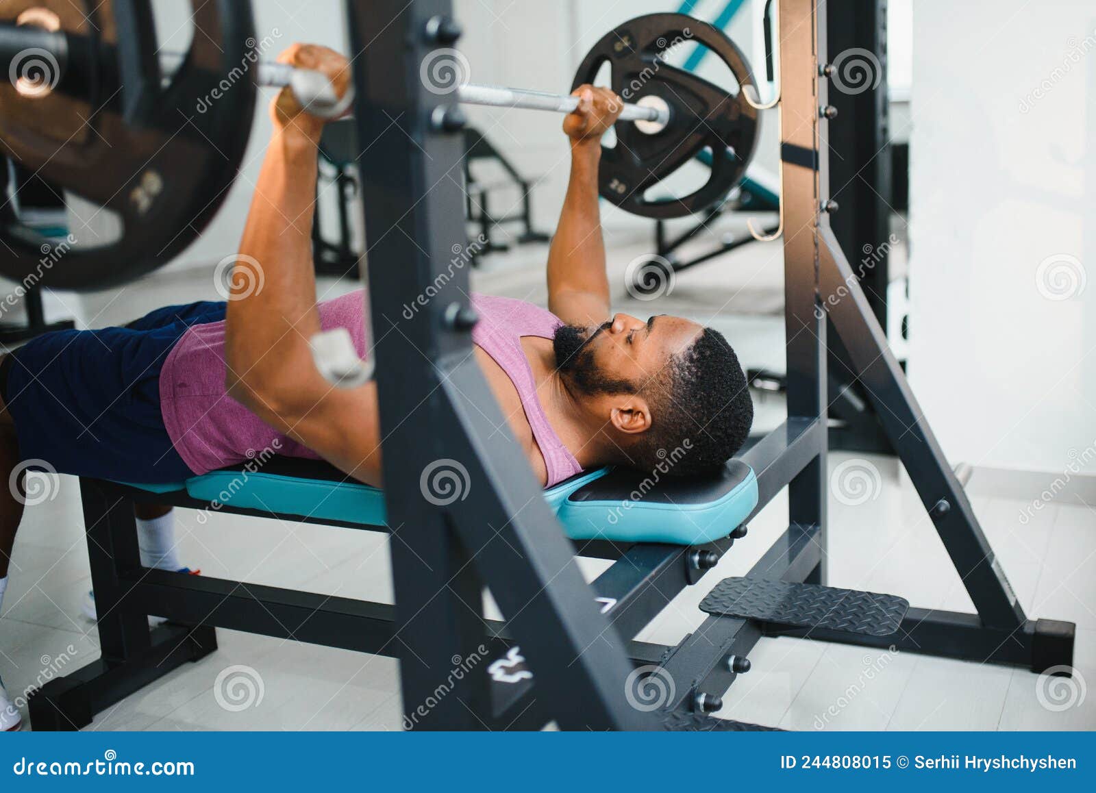 Weight Lifter at the Bench Press Lifting a Barbell on an Bench. Stock