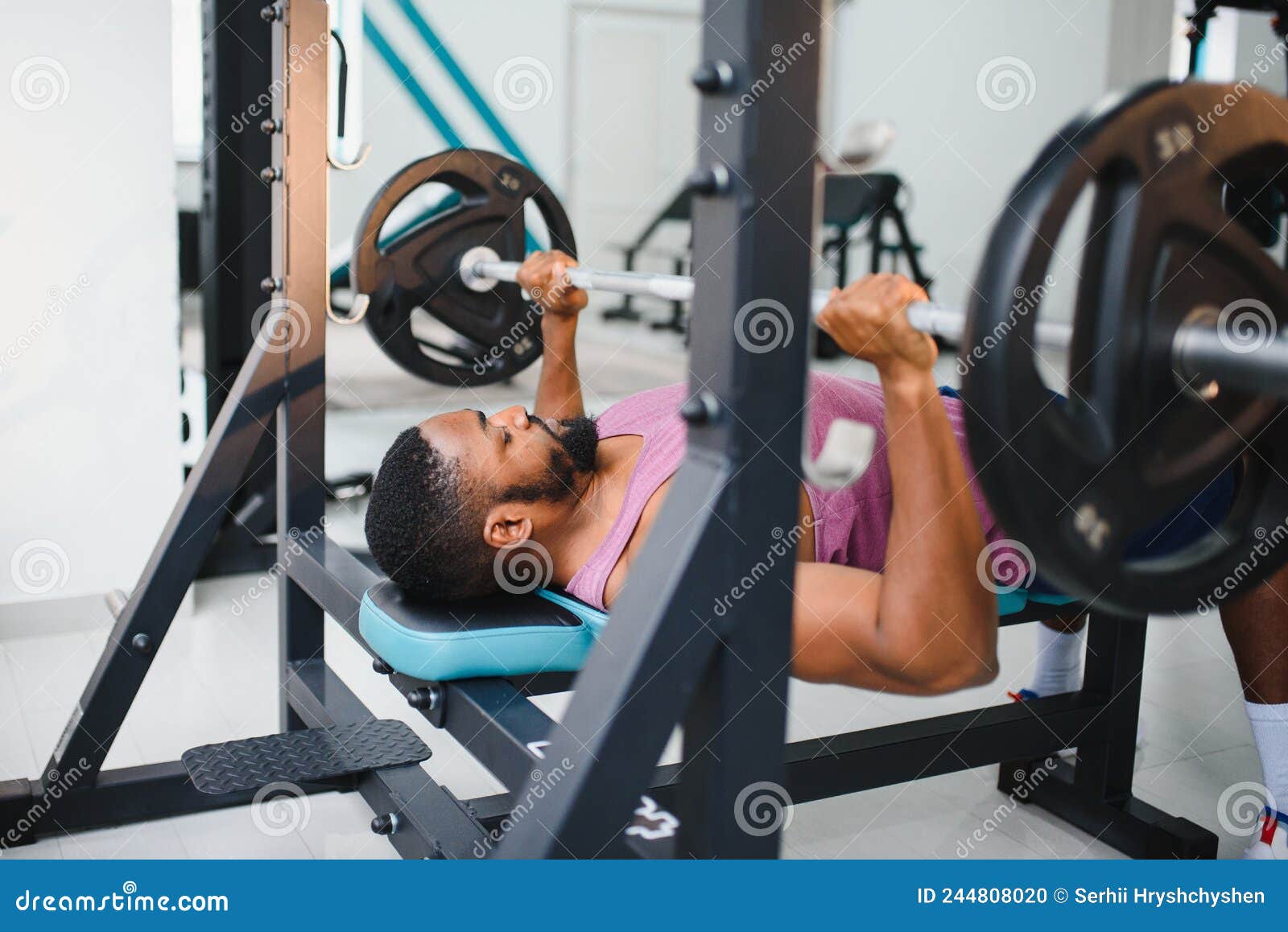 Weight Lifter at the Bench Press Lifting a Barbell on an Bench. Stock