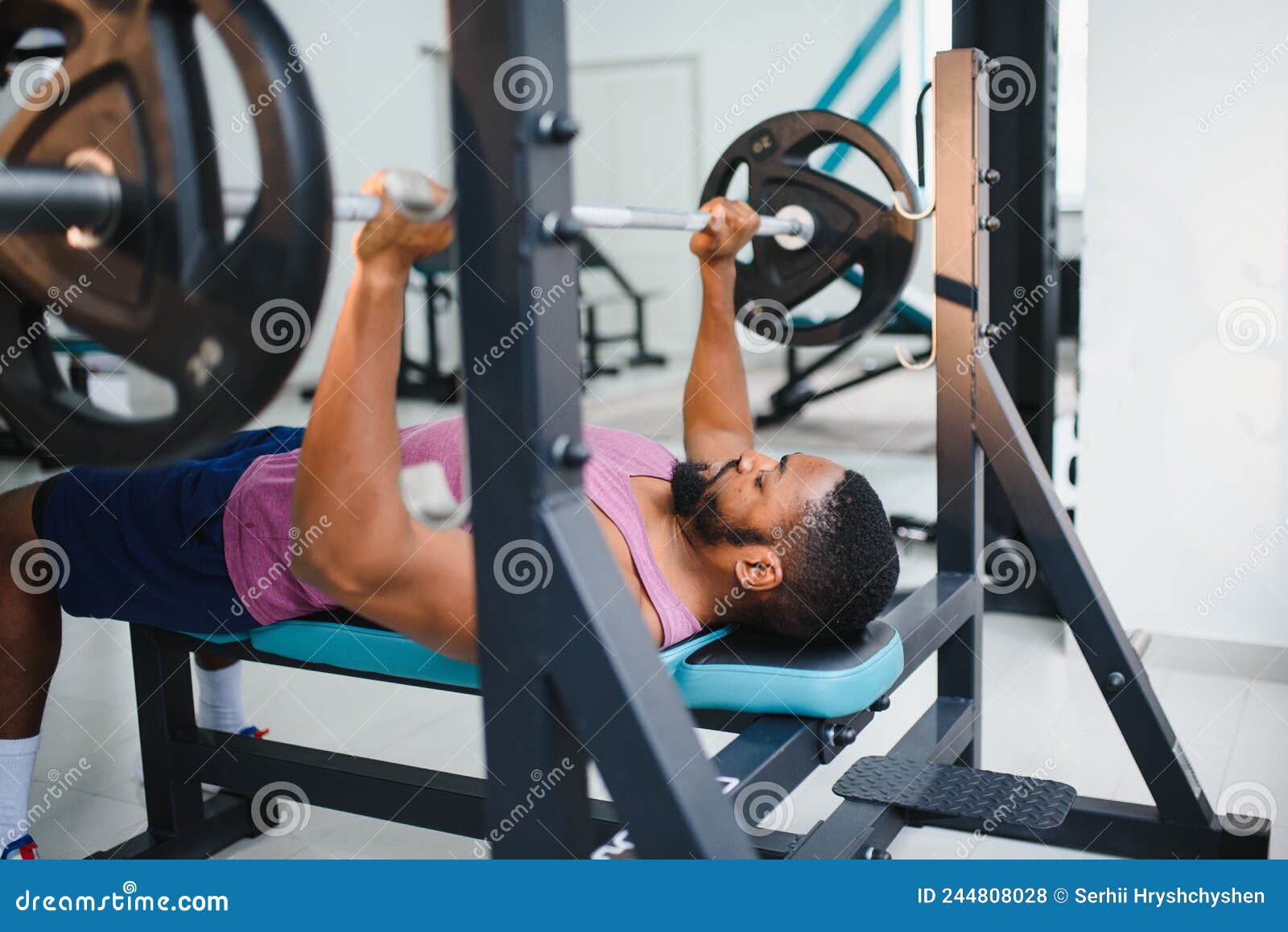 Weight Lifter at the Bench Press Lifting a Barbell on an Bench. Stock