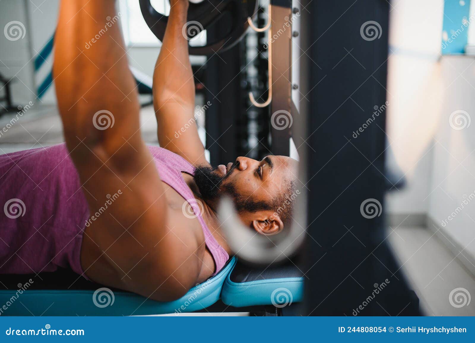 Weight Lifter at the Bench Press Lifting a Barbell on an Bench. Stock