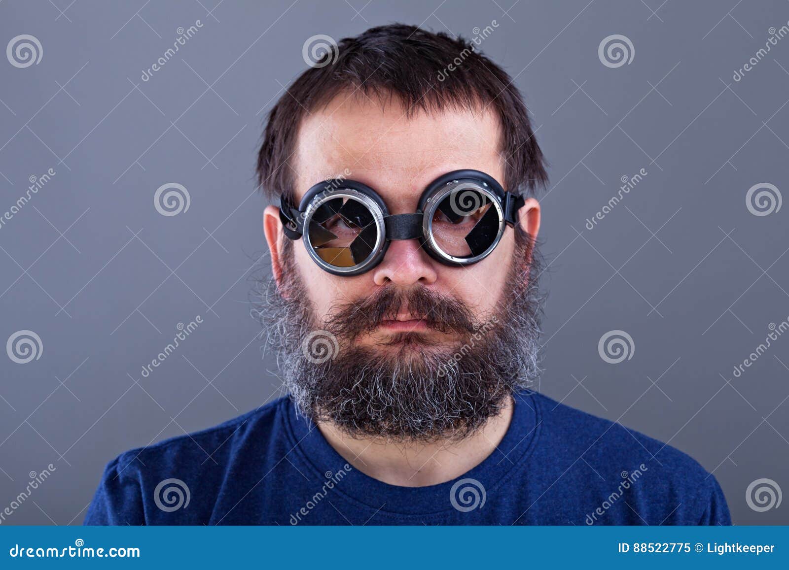 weird guy with matted hair and large beard wearing broken welding goggles