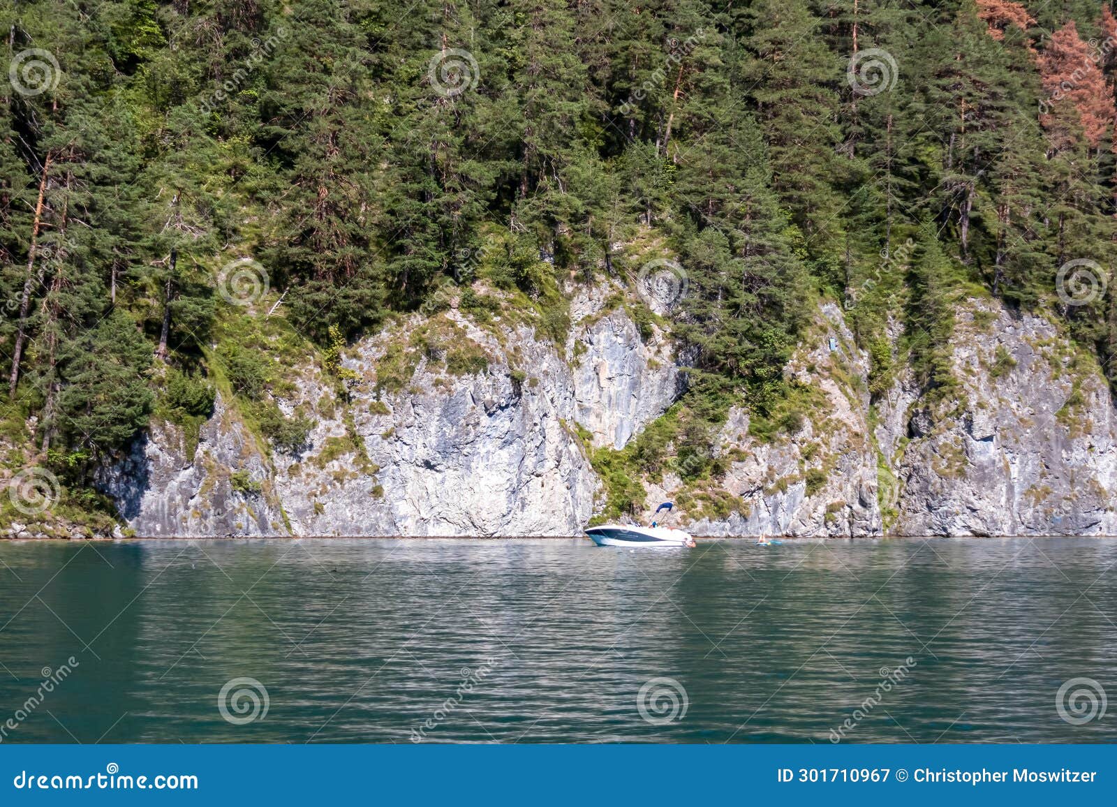 weisensee - rocky cliffs along the lakeshore of alpine lake weissensee in carinthia