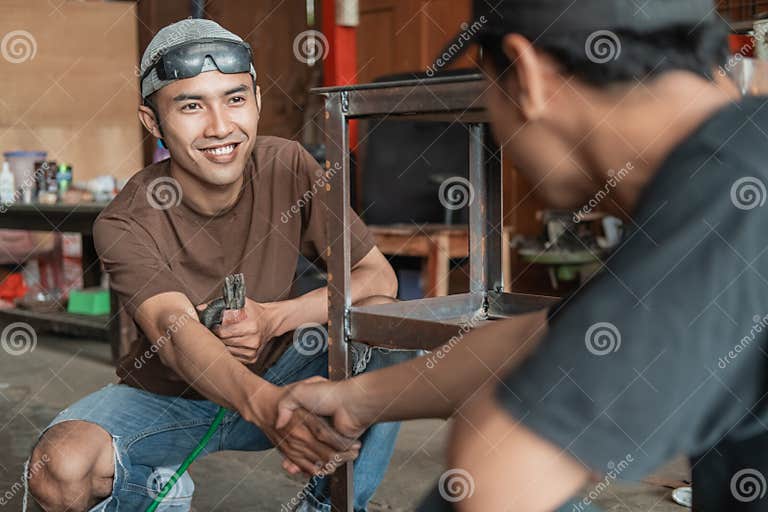 welder-and-the-customer-shake-hands-after-completing-the-iron-rack