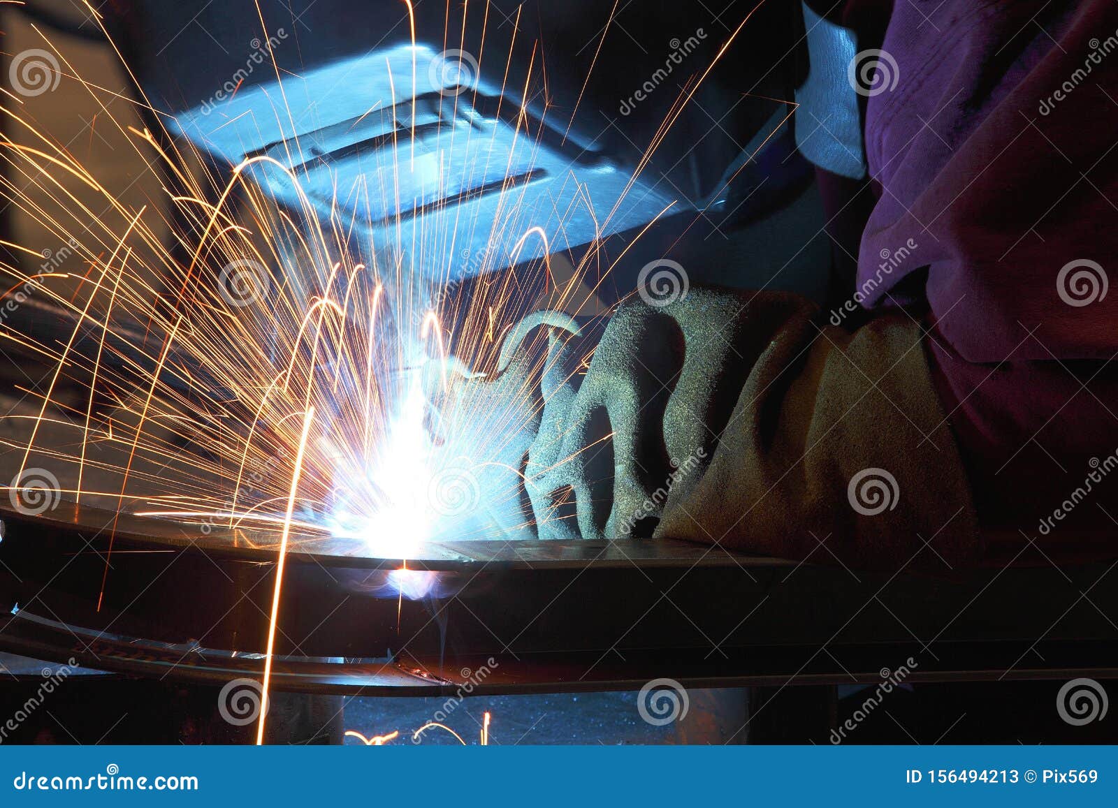 a welder using a wire feed welder to join two pieces of metal together.