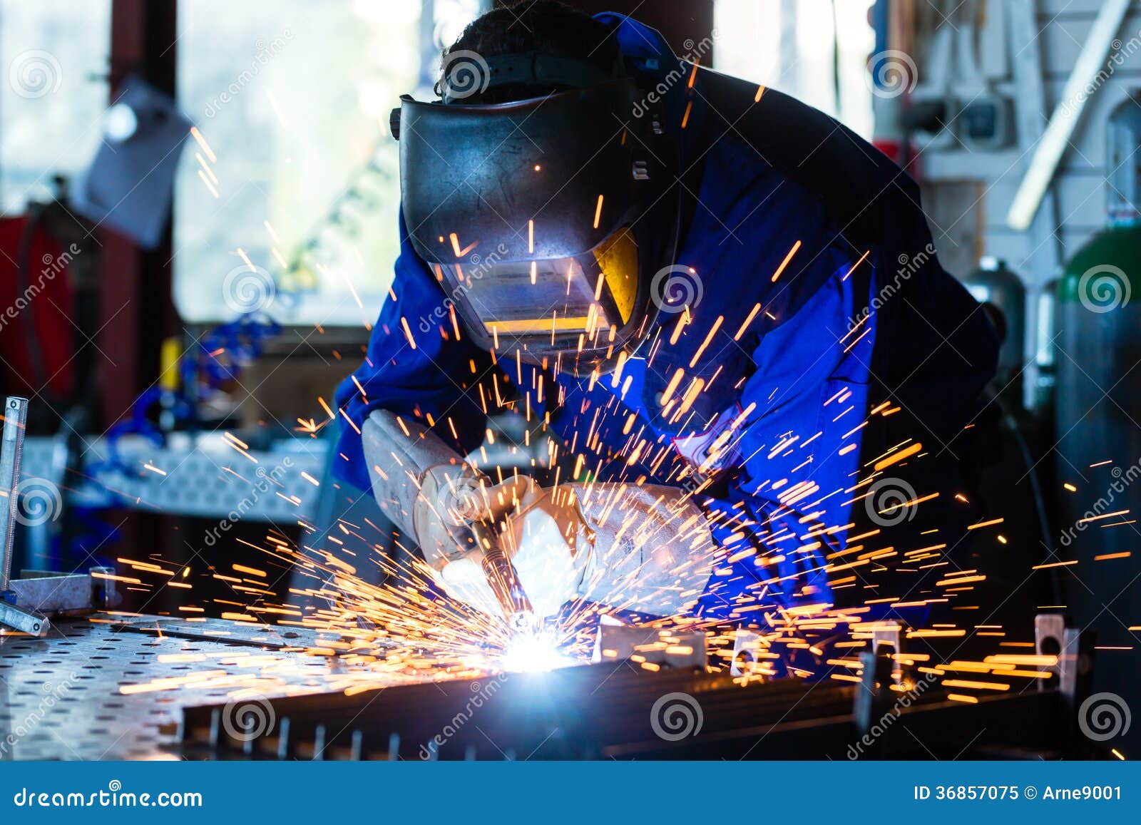 welder welding metal in workshop with sparks