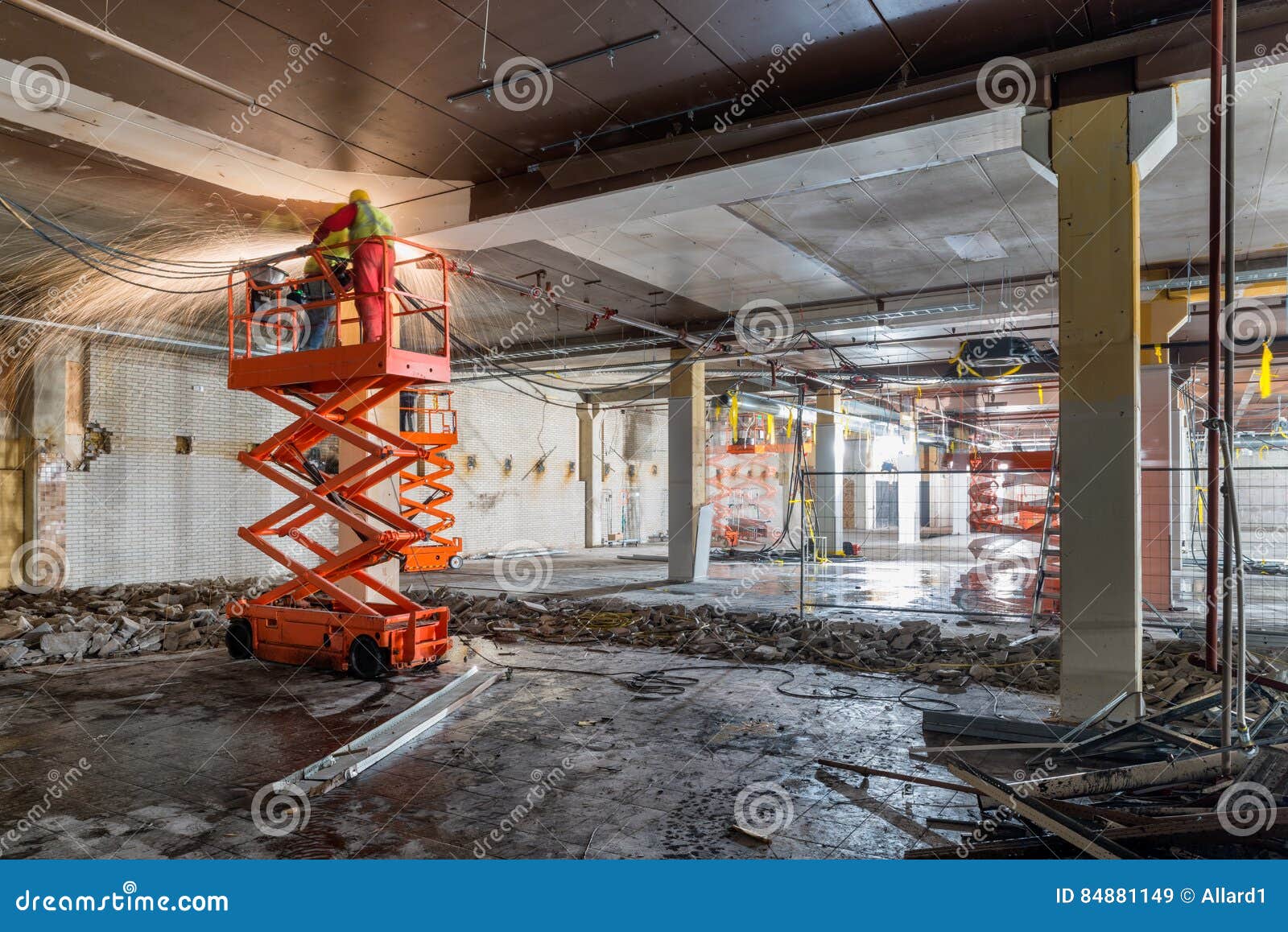 welders on scissor lift at construction site