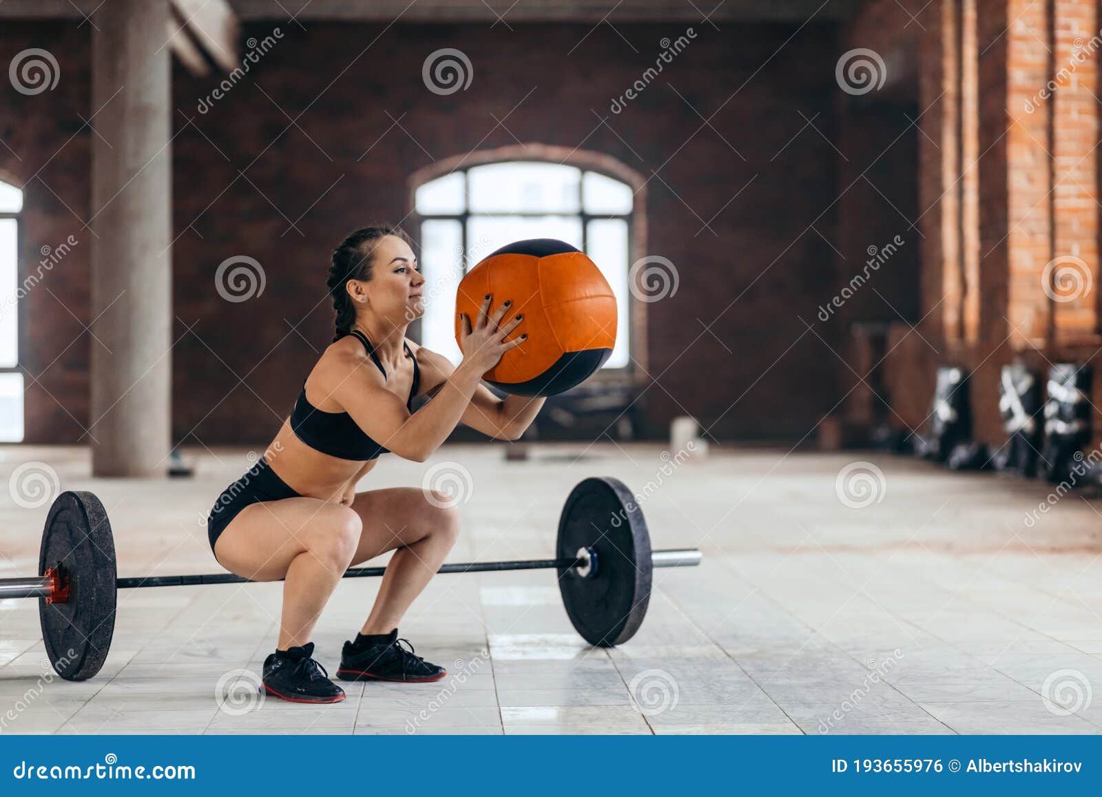 Well-built Motivated Girl Doing Squat Exercises with Fitness Ball ...
