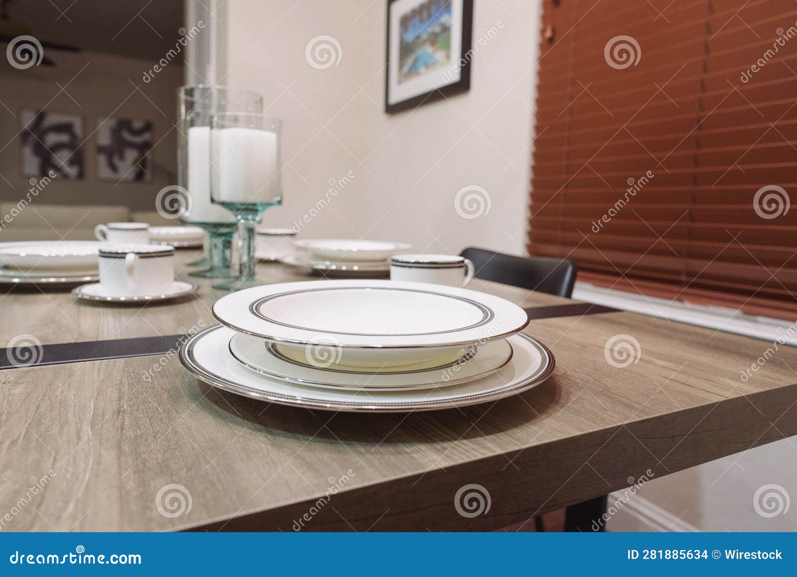well-set dinner table with two plates and candles