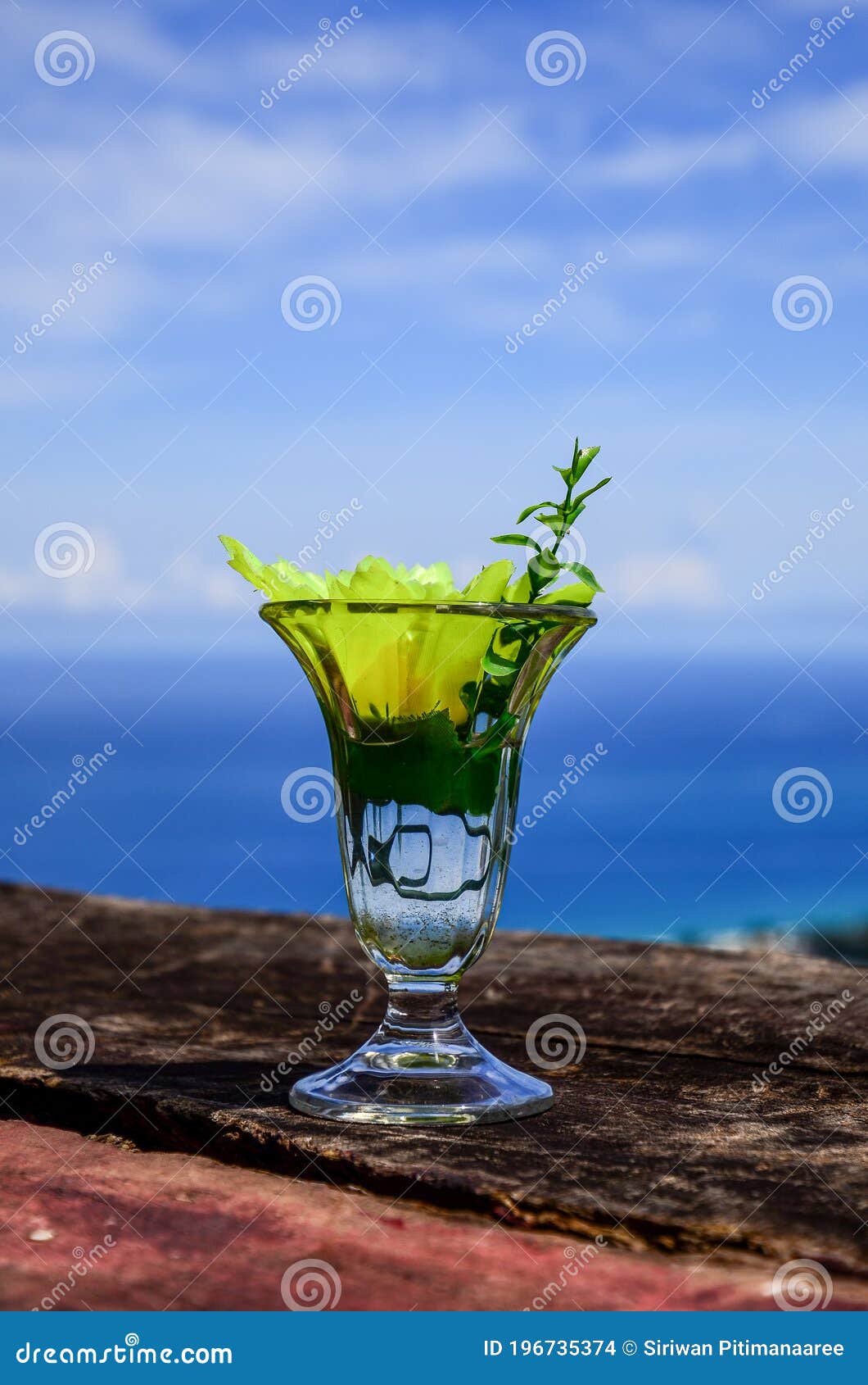 wellcome drink : cold water and yellow flower in clear glass on blue sky background