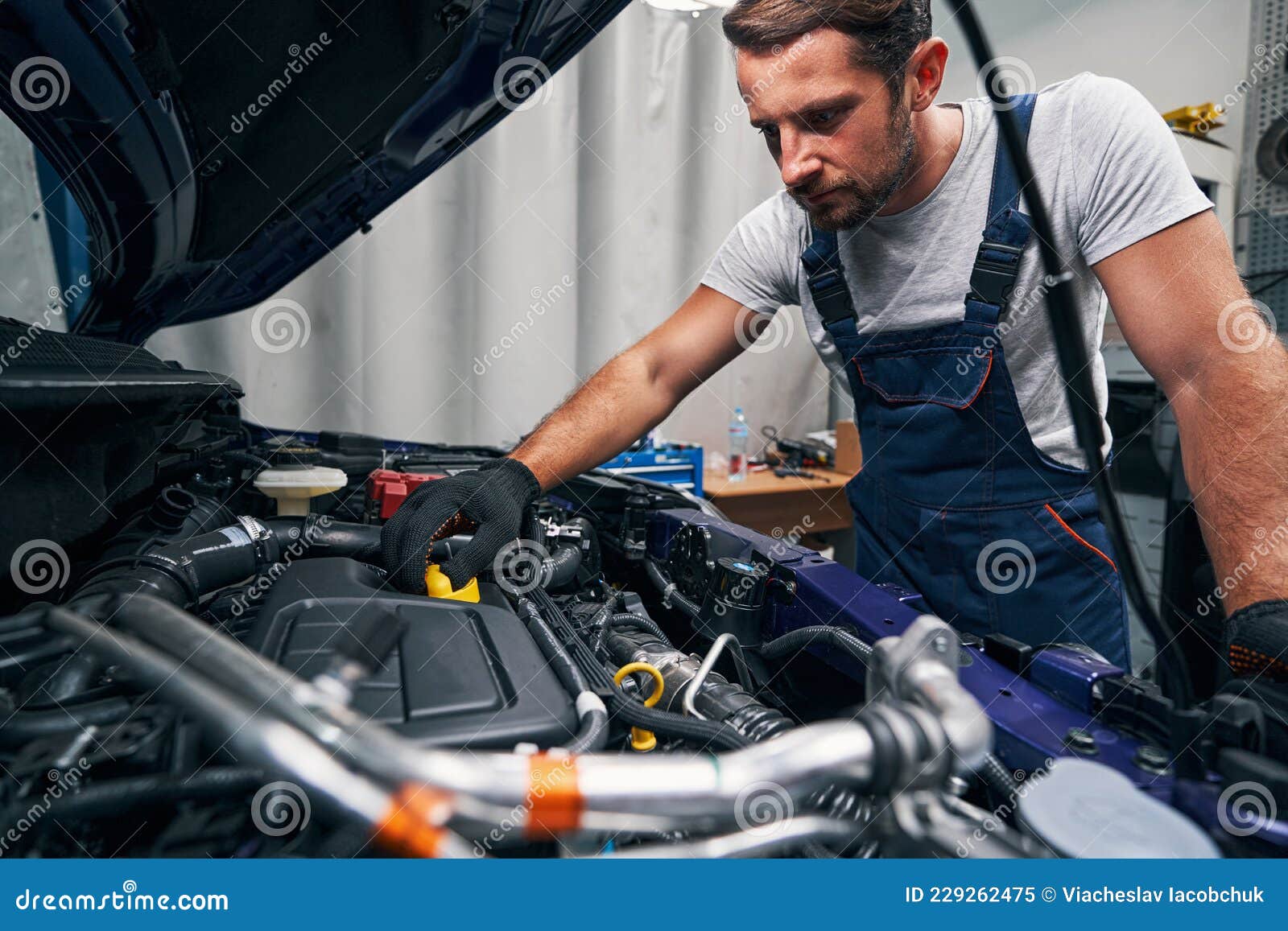 https://thumbs.dreamstime.com/z/werkstatttechniker-%C3%B6ffnet-%C3%B6lwanne-ruhiger-mann-der-die-kappe-von-des-motors-abdreht-w%C3%A4hrend-er-seinen-zustand-%C3%BCberpr%C3%BCft-229262475.jpg