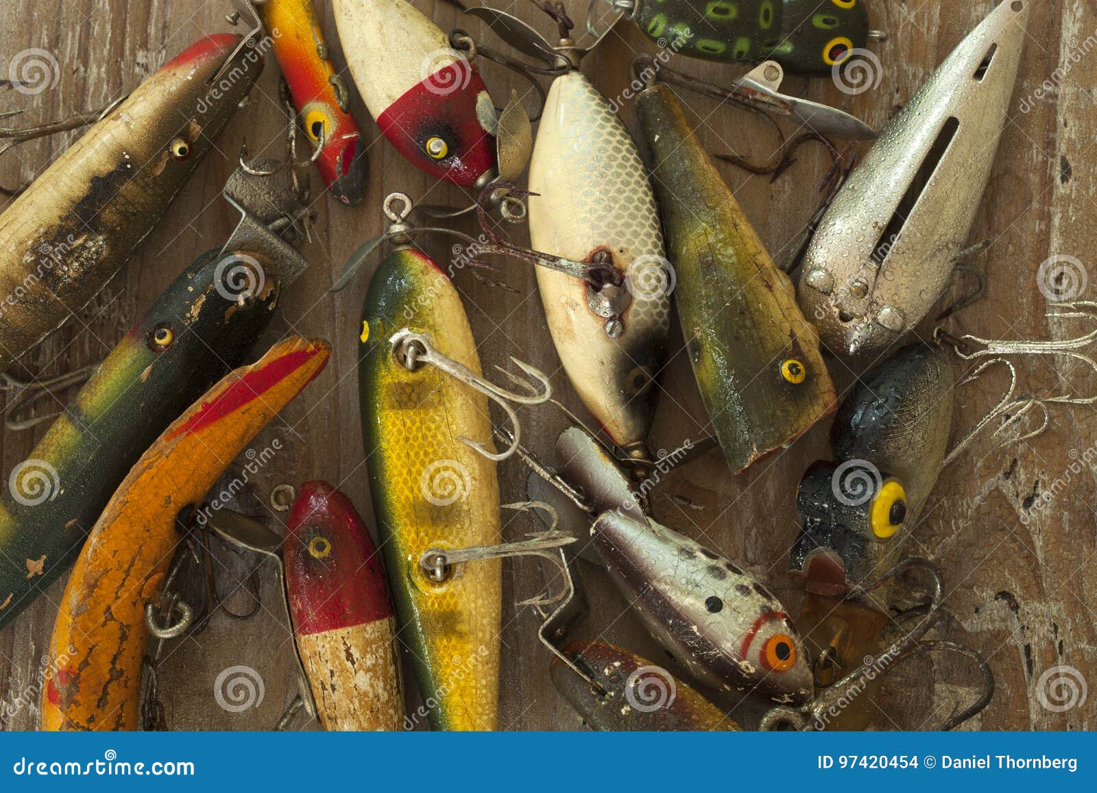 Wet Antique Fishing Lures Viewed from Above on a Rough Wood Surf