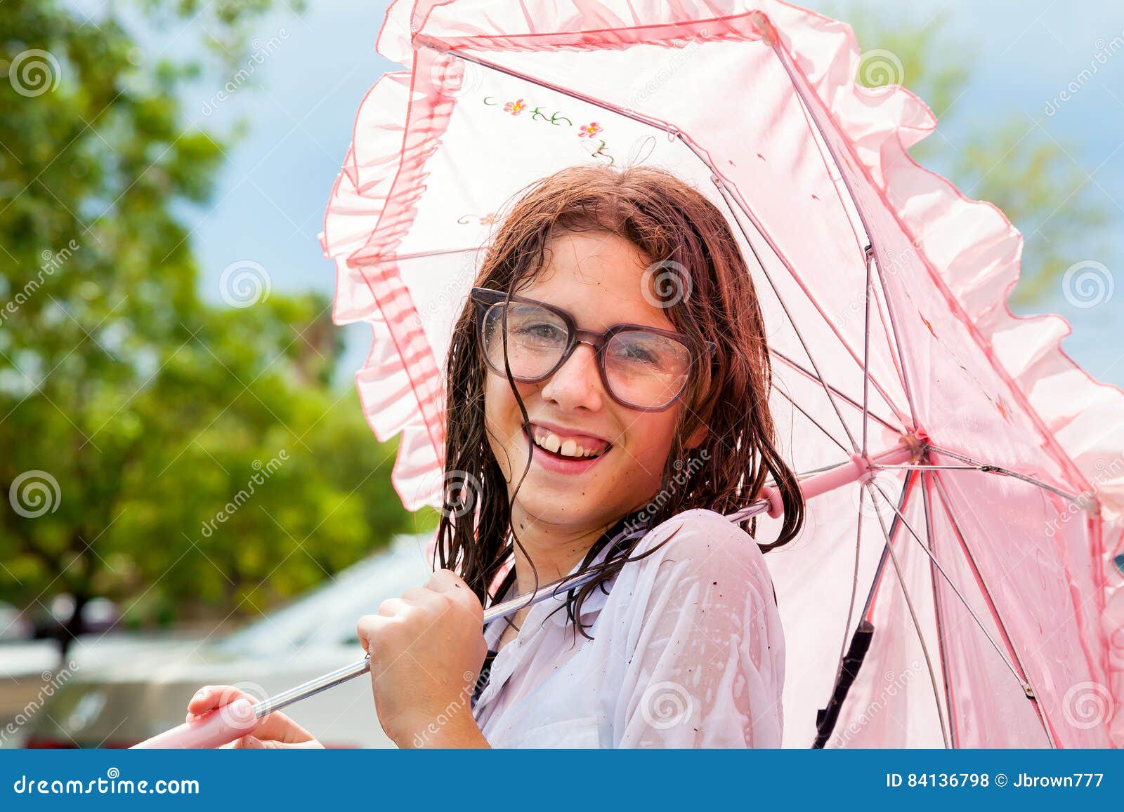 wet girl holding frilly umbrella and wearing water spotted glass