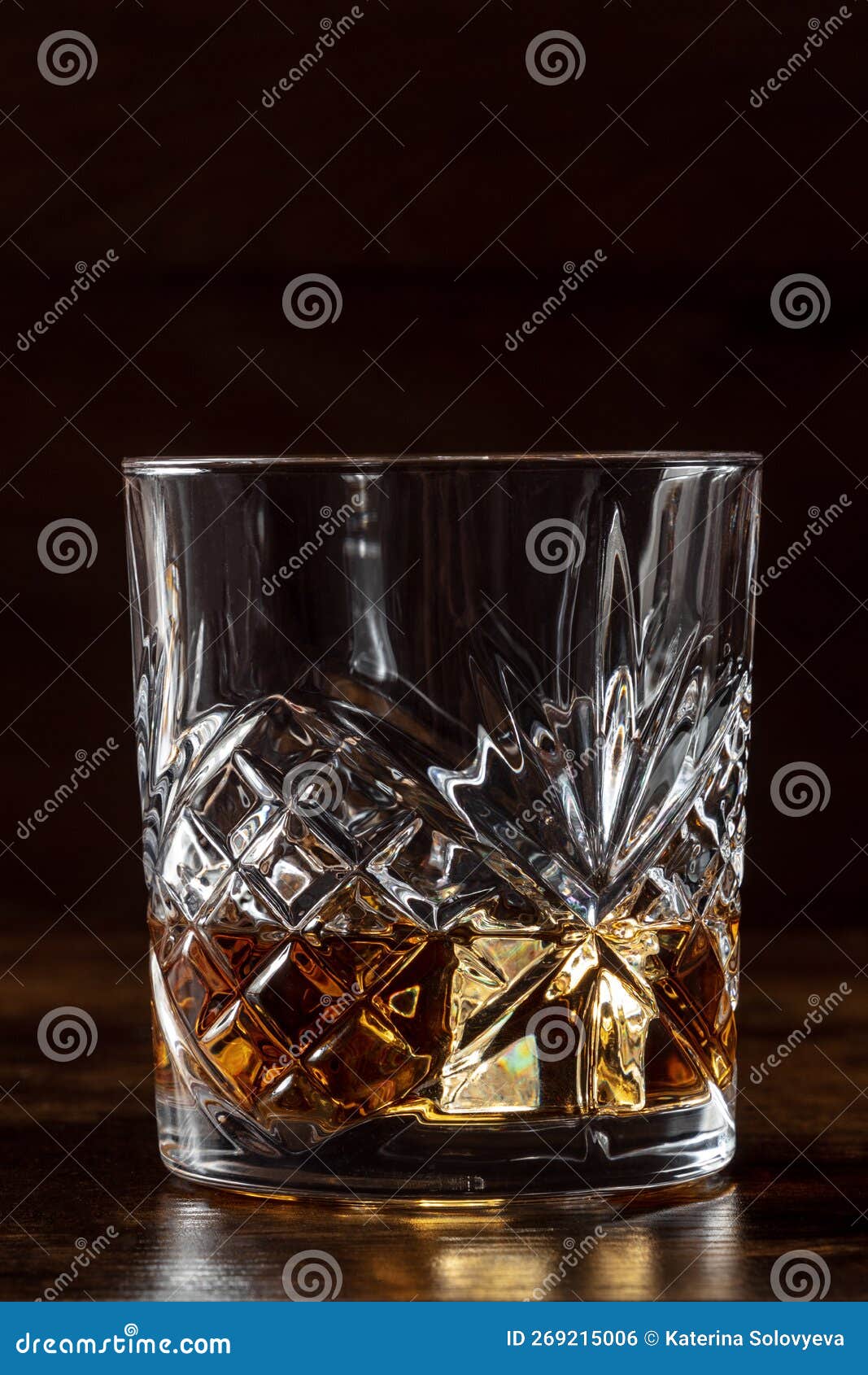 whiskey in a glass with ice. bourbon whisky on rocks on a dark background