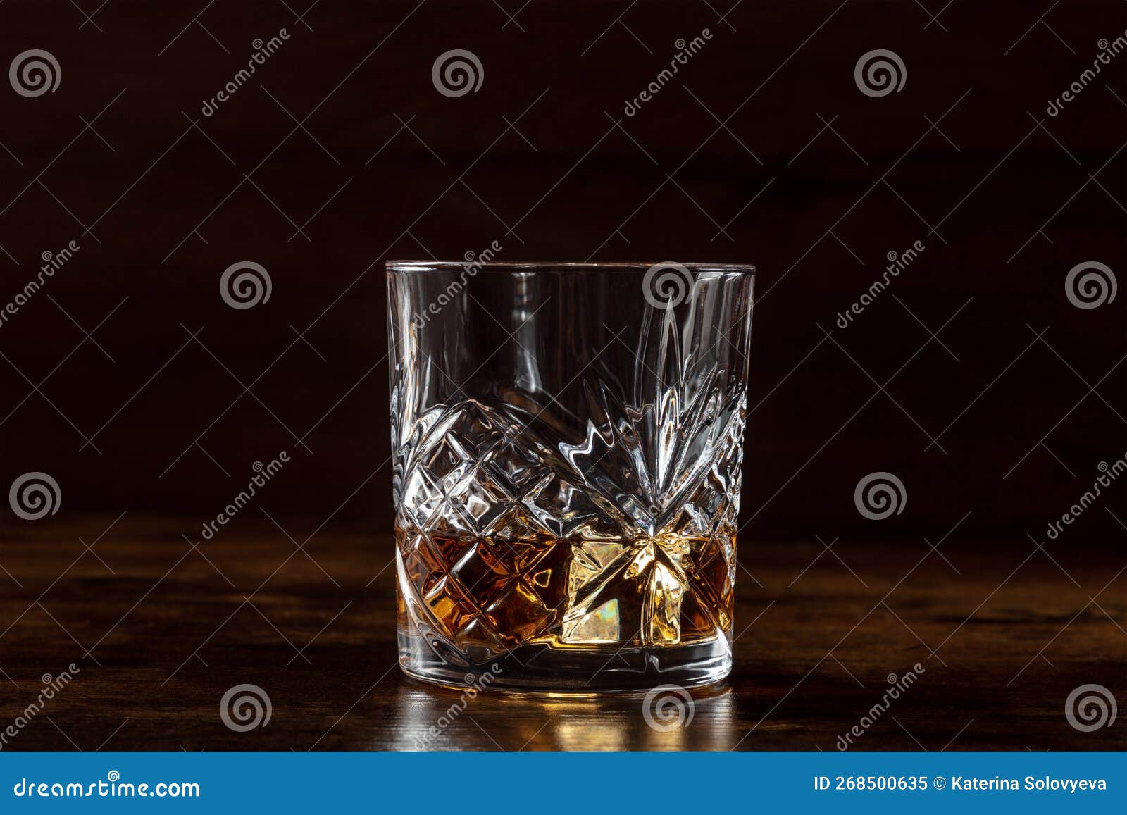 whiskey in a glass with ice. bourbon whisky on rocks on a dark background
