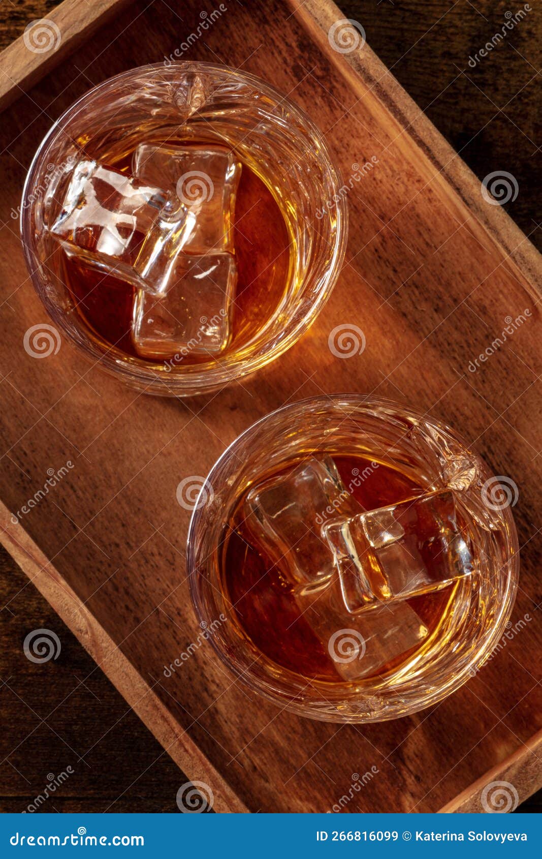 whiskey in glasses with ice. bourbon whisky on rocks on a dark background