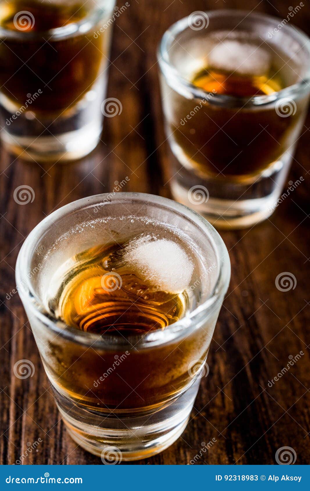 Whiskey Shots with Ice on Dark Wooden Surface. Stock Image Image of