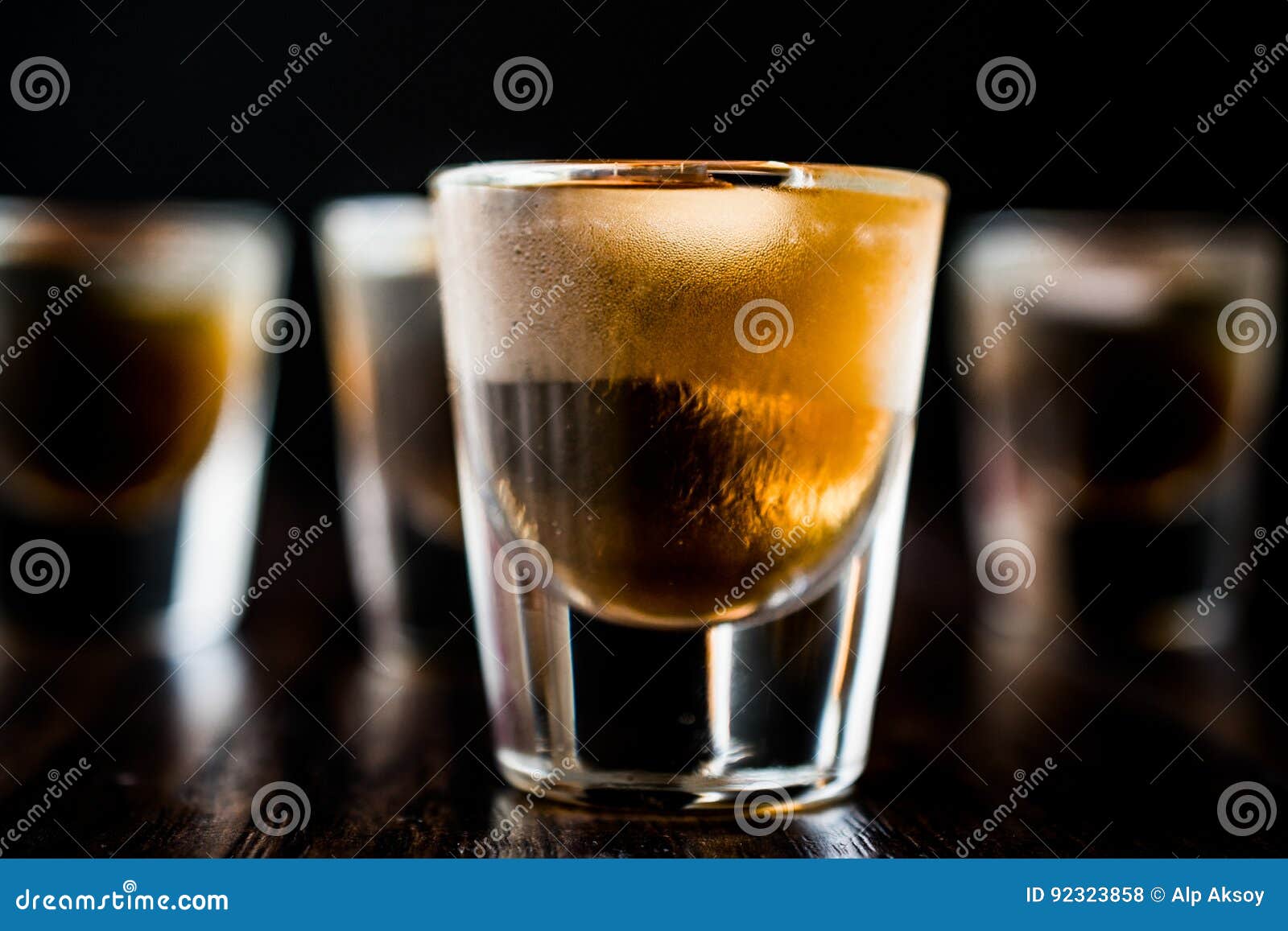 Whiskey Shots with Ice on Dark Wooden Surface. Stock Photo Image of