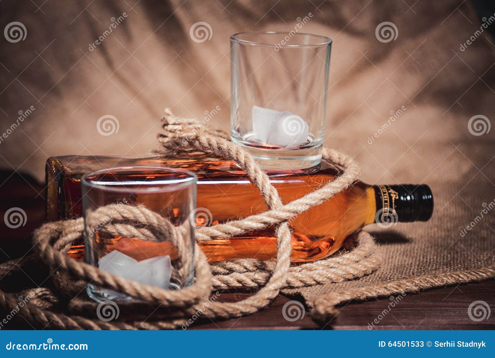 Whisky Glass with Ice, a Bottle of Whiskey and a Rope Stock Image