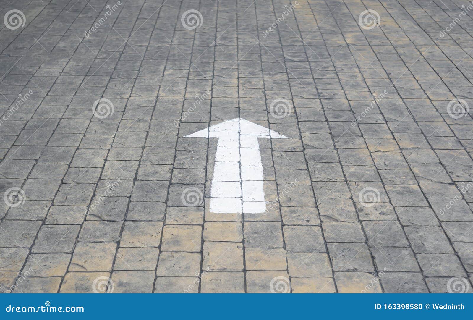 white arrow lines, concrete blocks paved surface, perpective view