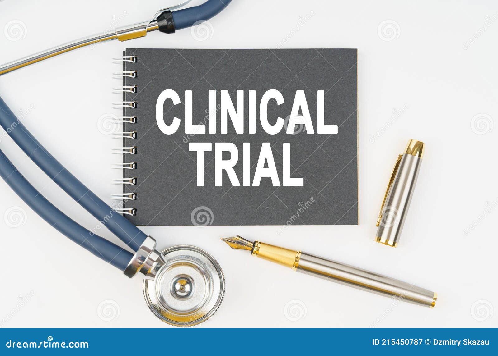 on a white background lie a stethoscope, a pen and a notebook with the inscription - clinical trial