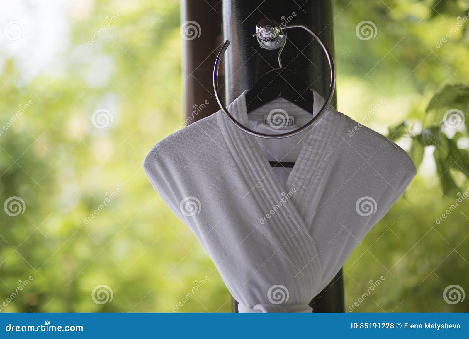 White Bathrobe Hanging on a Hanger in a Bathroom Design in the O Stock