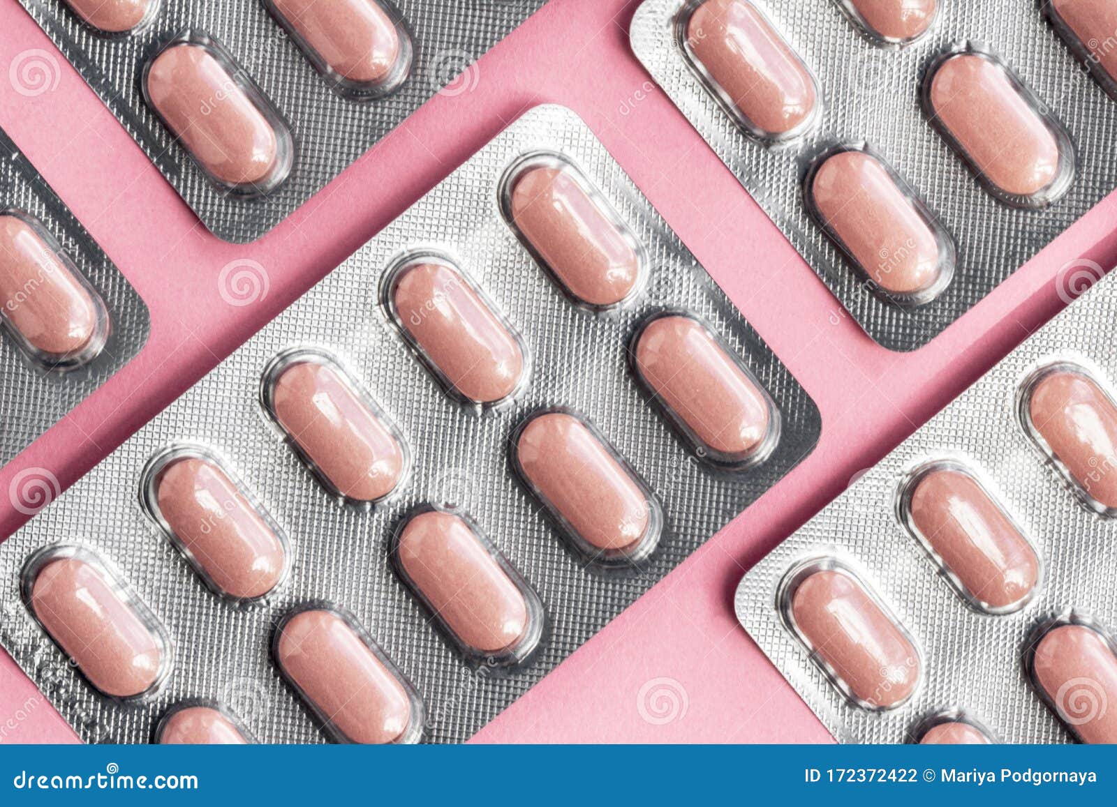 white blister pack of tablets pill statins for light resistance packaging on pink background. pink tablets