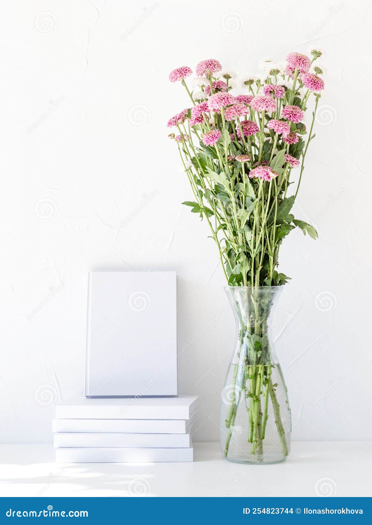White Book Mockup with Chrysanthemum Flowers in a Vase on a White Table
