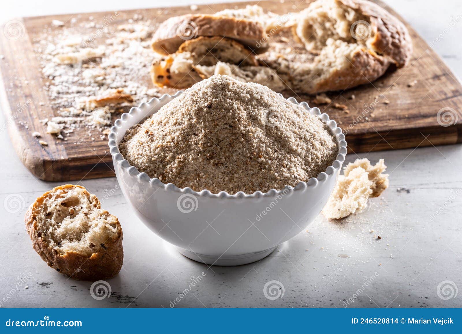 A White Bowl Full of Breadcrumbs and Old Dry Bread Around Stock Photo