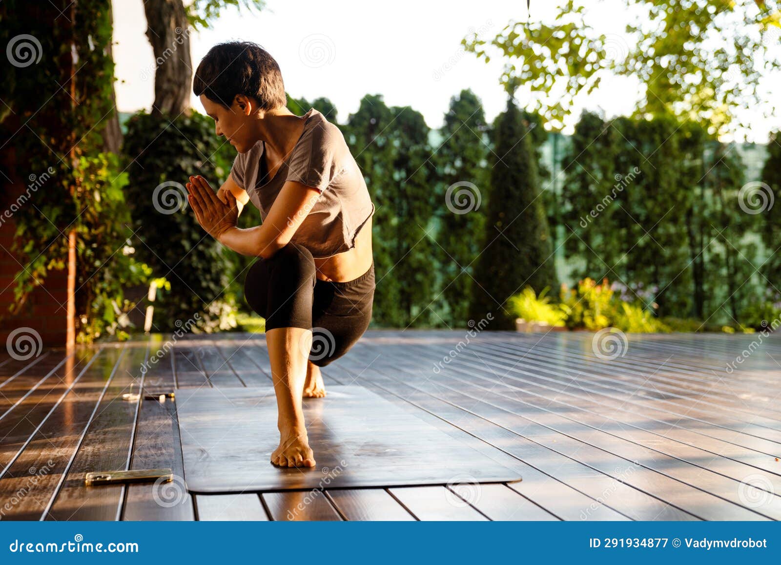 White Brunette Woman Doing Exercise During Yoga Practice Outdoors Stock White Brunette Woman Doing Exercise During Yoga Practice Outdoors Stock