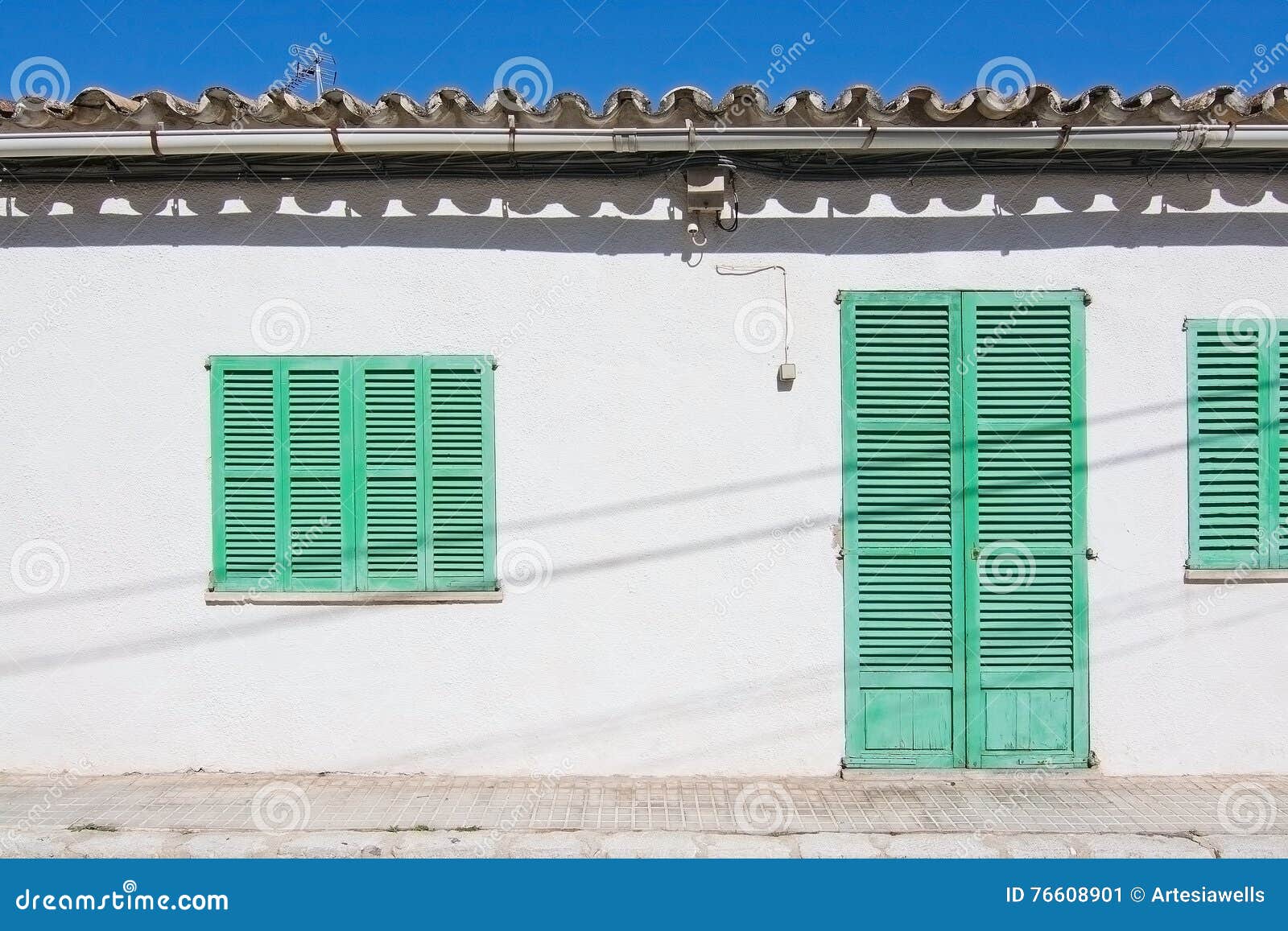 white building with green shutters in el terreno