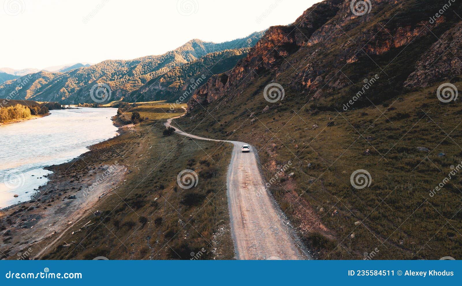 white car drives through narrow road in the mountains. drone footage