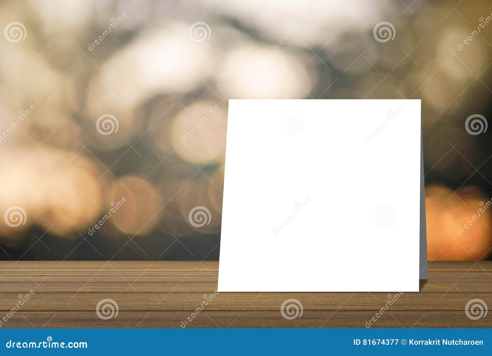 white card put on wood table and blurred bokeh out of focus in sunset moment background. product display template.