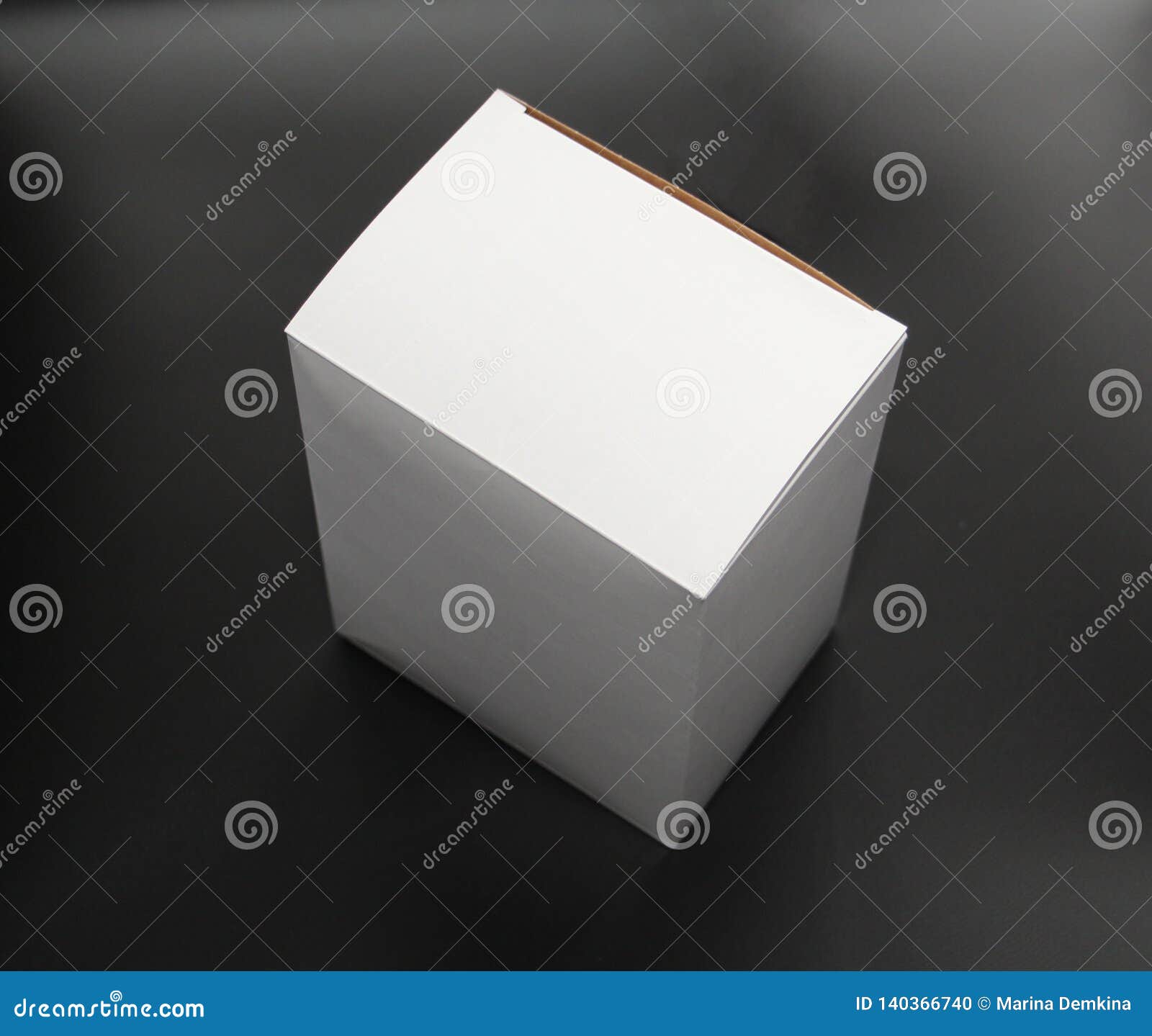 White Cardboard Box on a Black Background. the Box is Square in Shape