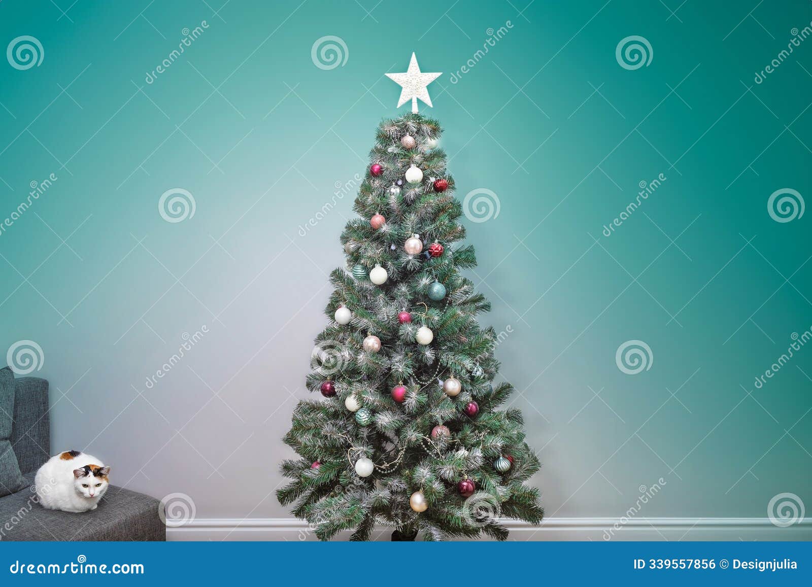 a white cat with black and red spots on its back and head sits on a sofa next to a beautiful christmas tree, new year's cozy