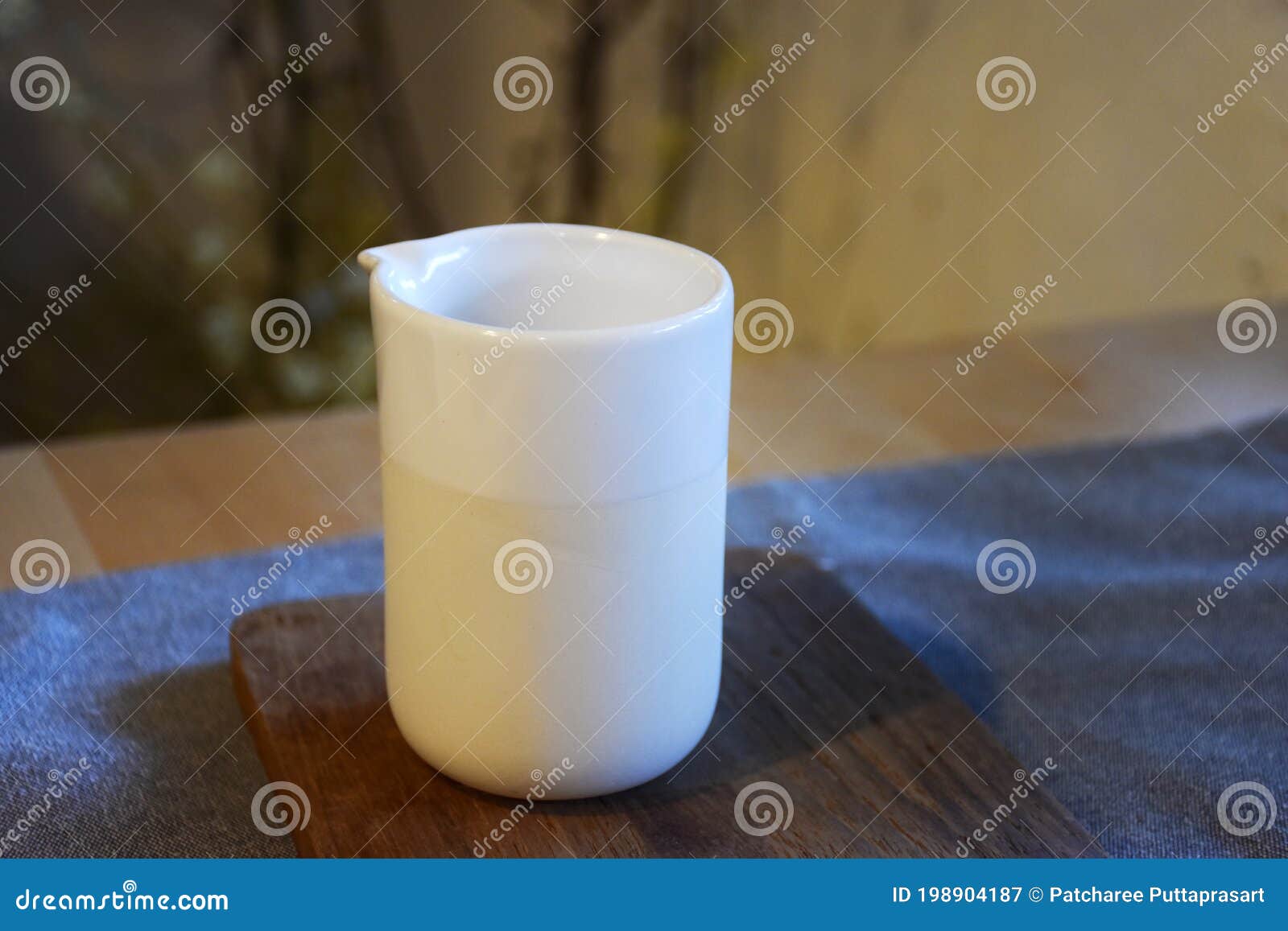 white ceramic cup on wooden plate and on tablen