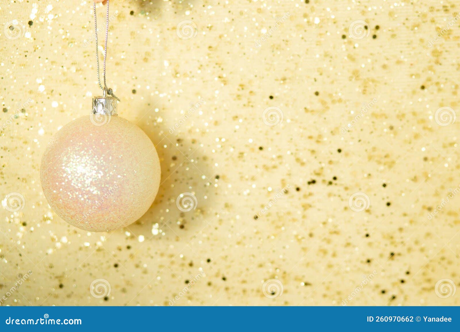 White Christmas Ball on Gold Background with Sparkles with Copy Space