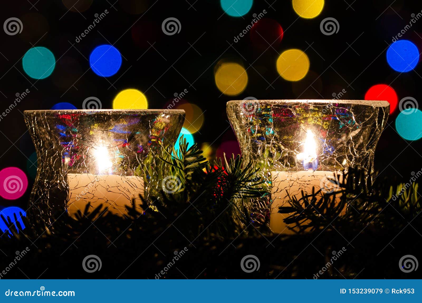 White Christmas Candles Surrounded by Christmas Lights and Evergreen