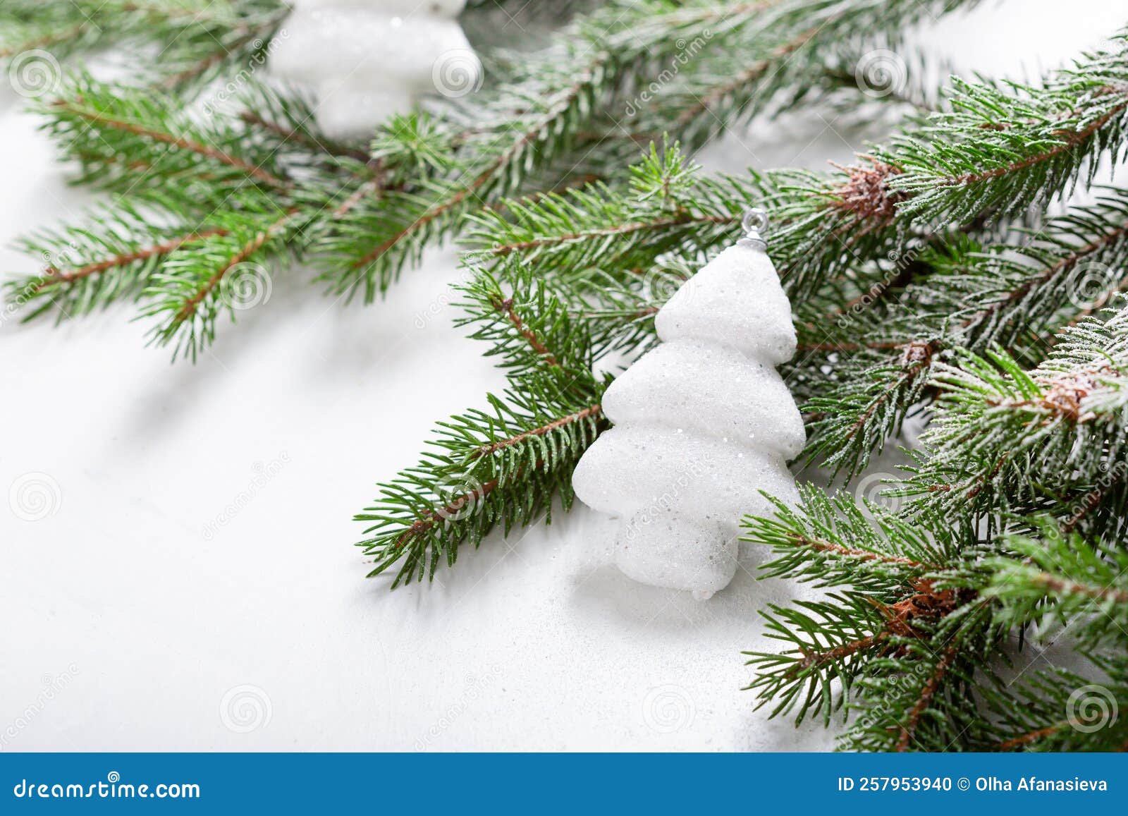 White Christmas Tree and Green Branches on Light Surface Holiday