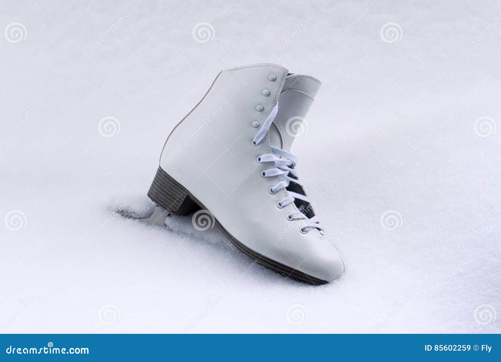 white classical iceskate shoe partially covered in snow