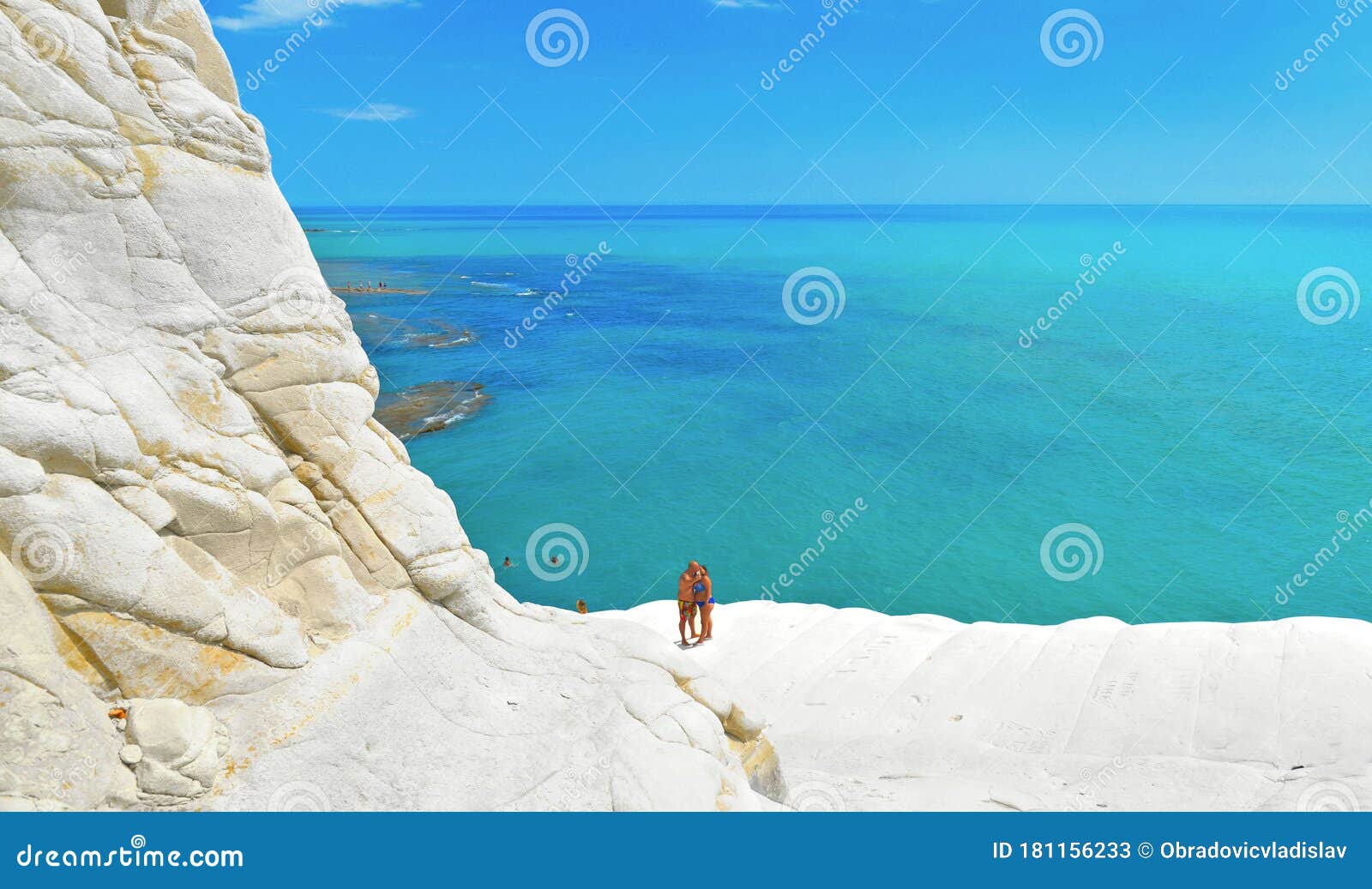 white cliffs naturally made of smooth pug at scala dei turchi beach with group of young people and turquoise mediterra