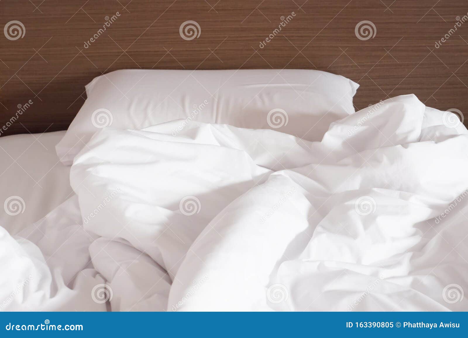 White Crumpled Bed Sheet and Messy Pillows in a Hotel Room Stock Image
