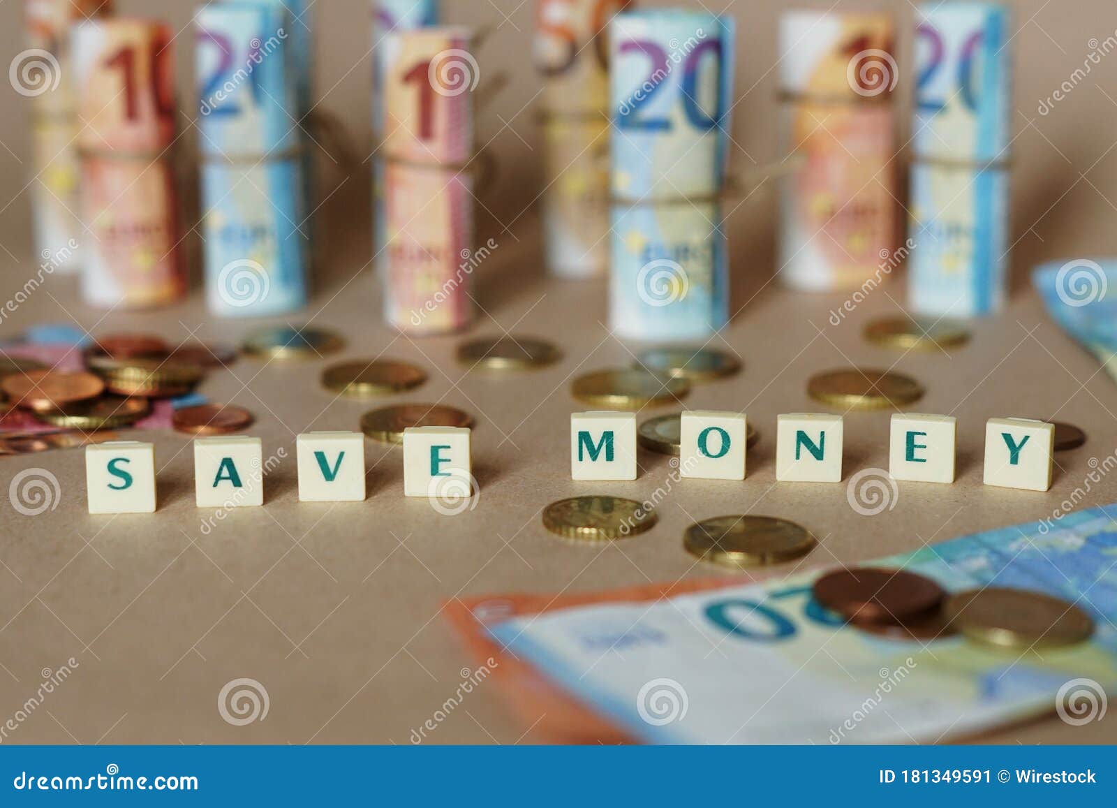 cubes spelling save money on the table with spanish dinero bills and coins